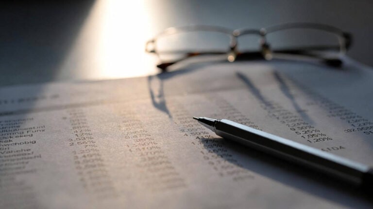 Migliori gestori fondi 2026: report con rendimenti percentuali, penna e occhiali su tavolo